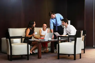 a group of people sitting around a table with a laptop at HCC St. Moritz in Barcelona