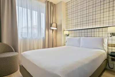 a bedroom with a large white bed and a window at Acta CITY47 in Barcelona