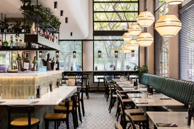 a restaurant with tables and chairs and windows at Acta CITY47 in Barcelona