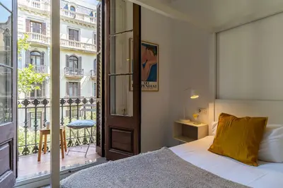 a bedroom with a bed and a large window at Canela Homes BARCELONA CASP in Barcelona