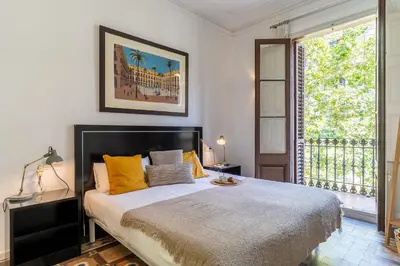 a bedroom with a bed with yellow pillows and a window at Canela Homes BARCELONA CASP in Barcelona