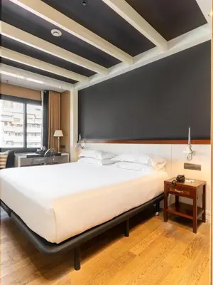 a bedroom with a large white bed and a black wall at U232 Hotel in Barcelona
