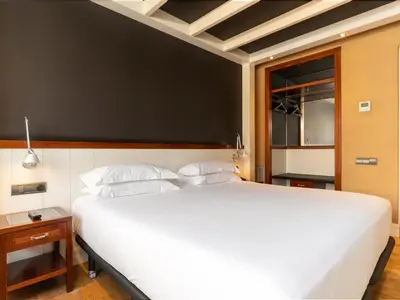 a bedroom with a large white bed and a black wall at U232 Hotel in Barcelona