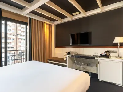 a hotel room with a bed and a desk and a kitchen at U232 Hotel in Barcelona