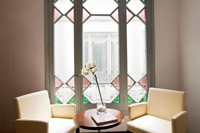 two chairs and a table in front of a window at Grupotel Gravina in Barcelona