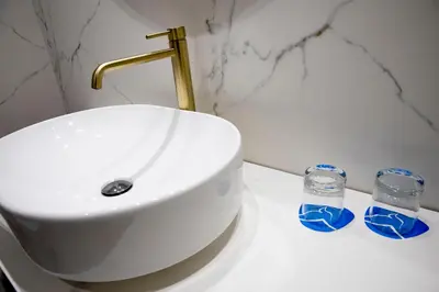 a bathroom with a sink and two glasses on a counter at Grupotel Gravina in Barcelona