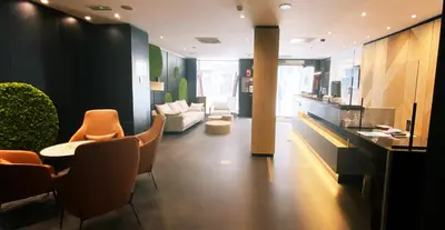 a living room with a couch and a table and chairs at Ilunion Almirante in Barcelona