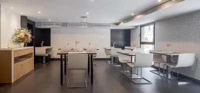 a dining room with tables and white chairs at Ilunion Almirante in Barcelona