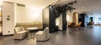 a lobby with chairs and a table in a building at Ilunion Almirante in Barcelona