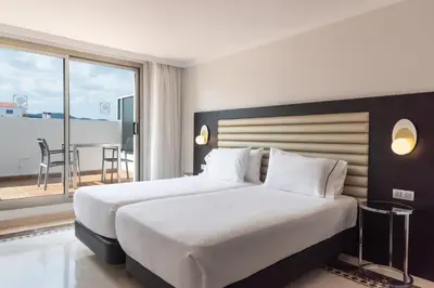a hotel room with a large bed and a balcony at Eurostars Cristal Palace in Barcelona