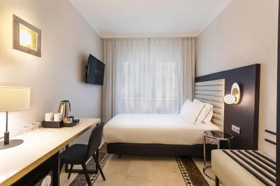 a hotel room with a bed and a desk at Eurostars Cristal Palace in Barcelona