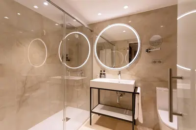 a bathroom with a sink and two mirrors at Eurostars Cristal Palace in Barcelona