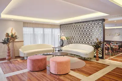 a living room with white furniture and pink stools at Exe Mitre in Barcelona