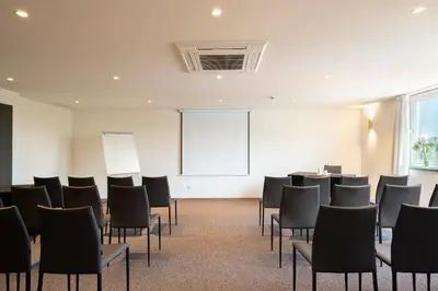 a conference room with black chairs and a whiteboard at Exe Parc del Vallés in Cerdanyola del Valles