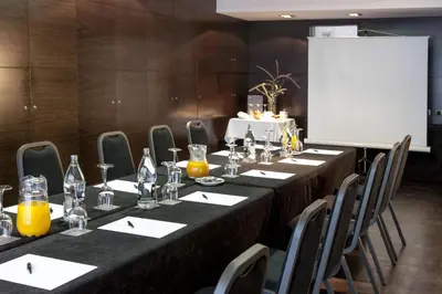 a conference room with a long table with chairs and a screen at Zenit Barcelona in Barcelona