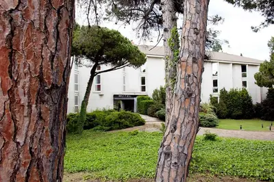 two trees in front of a white building at Hotel Punt 14 in Gavà