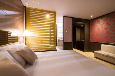 a bedroom with a large bed and a couch at Hotel Punt 14 in Gavà