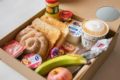 a box filled with breakfast foods and a banana at Hotel Punt 14 in Gavà
