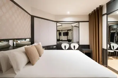 a bedroom with a large white bed and two chairs at Hotel Punt 14 in Gavà