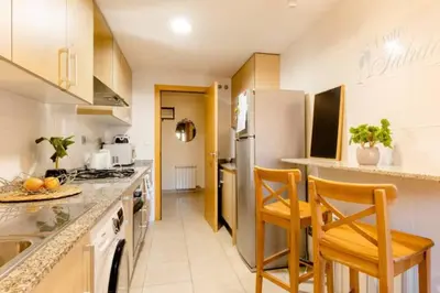 a kitchen with a refrigerator and two chairs in it at Apt.p/5 15min from Barcelona and Beaches W/Terrace in Sant Adria de Besos