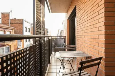 a balcony with a table and chairs on a brick building at Apt.p/5 15min from Barcelona and Beaches W/Terrace in Sant Adria de Besos