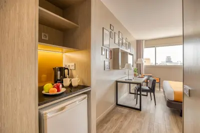 a room with a kitchen and a dining room at Citadines Ramblas Barcelona in Barcelona