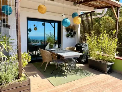 a patio with a table and some plants and lights at Cozy place, big roof terrace & spectacular views. in Cabrils