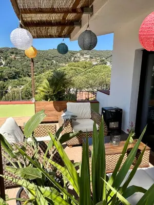 a patio with a chair and a table and some plants at Cozy place, big roof terrace & spectacular views. in Cabrils