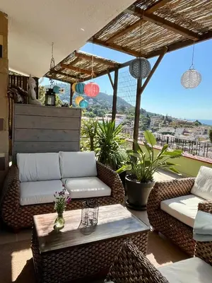 a patio with couches and a table on a balcony at Cozy place, big roof terrace & spectacular views. in Cabrils