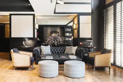 a bedroom with a bed and a chair and windows at Europark in Barcelona