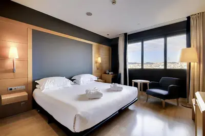 a large swimming pool in front of a house at Hotel Barcelona Universal in Barcelona