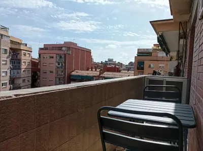 a bench on a balcony with a view of a city at COOL! 5' to metro. 15' to Center/beach by metro. in Santa Coloma de Gramanet