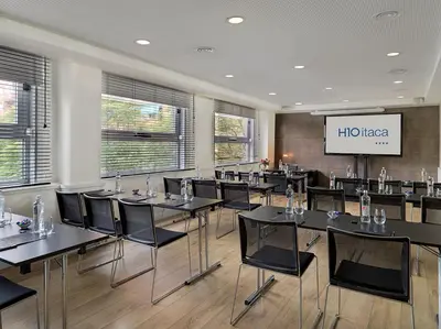 a conference room with tables and chairs and a screen at H10 Itaca in Barcelona