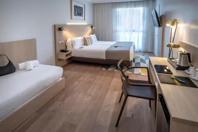 a hotel room with two beds and a desk at Hotel SERHS Rivoli Rambla in Barcelona