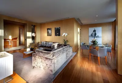 a living room with a stone fireplace and a table at Eurostars Grand Marina Hotel GL in Barcelona