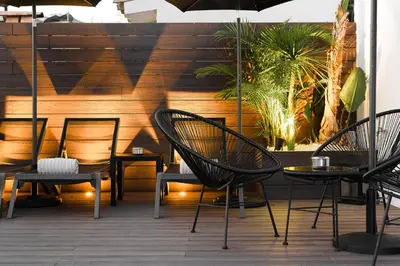 a group of chairs and tables on a patio at Elite Hotel - Gay Men Only in Sitges