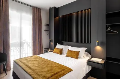 a bedroom with a large bed with yellow pillows at Elite Hotel - Gay Men Only in Sitges