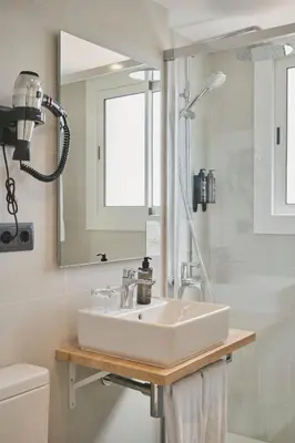 a bathroom with a sink and a mirror at Tres Torres Atiram Hotel in Barcelona