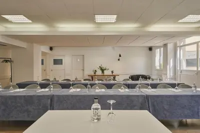 a large room with tables and chairs with bottles on them at Tres Torres Atiram Hotel in Barcelona