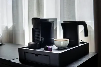 a black shelf with a coffee maker and a bowl at Tres Torres Atiram Hotel in Barcelona