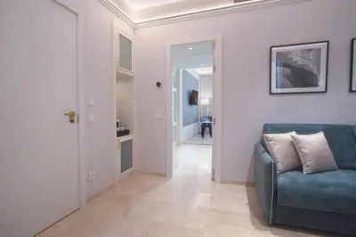 a living room with a blue couch and a hallway at Eurostars Laietana in Barcelona