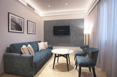 a living room with a blue couch and a table at Eurostars Laietana in Barcelona