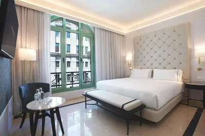 a bedroom with a bed and a table and a window at Eurostars Laietana in Barcelona