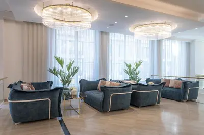 a living room with blue couches and chandeliers at Eurostars Laietana in Barcelona