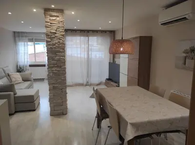 a living room with a table and a stone pillar at Apartamento en Viladecans cerca del aeropuerto in Viladecáns