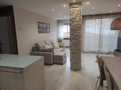 a living room with a couch and a stone pillar at Apartamento en Viladecans cerca del aeropuerto in Viladecáns