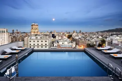 a rooftop pool with a view of a city at NH Collection Barcelona Gran Hotel Calderon in Barcelona