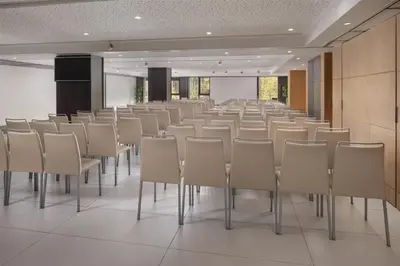 a conference room with rows of chairs and a podium at NH Collection Barcelona Gran Hotel Calderon in Barcelona