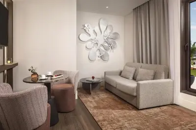 a living room with a couch and a chair and a table at NH Collection Barcelona Gran Hotel Calderon in Barcelona