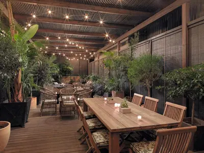 a patio with a wooden table and chairs and plants at Boutique Hotel H10 Catalunya Plaza in Barcelona